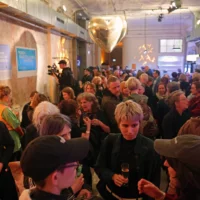 Gäste des Abends tummeln sich in Gespräche vertieft bei gedämpften Licht im Foyer der Sophiensaele.